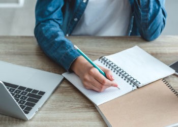 Berufsbegleitend studieren - Notizen und Laptop auf einem Tisch, Student lernt