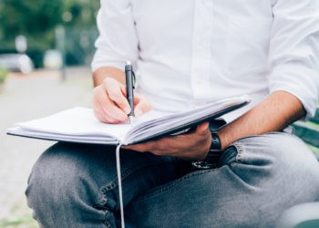 Junger Mann schreibt in sein Tagebuch, Journaling