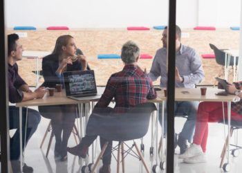 Meeting eines Startups, Team sitzt bei Besprechung zusammen am Tisch