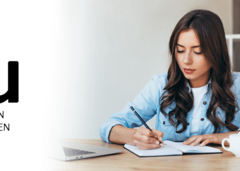 Studentin der IU sitzt am Schreibtisch und macht Steuern, IU Fernstudium Steuern absetzen